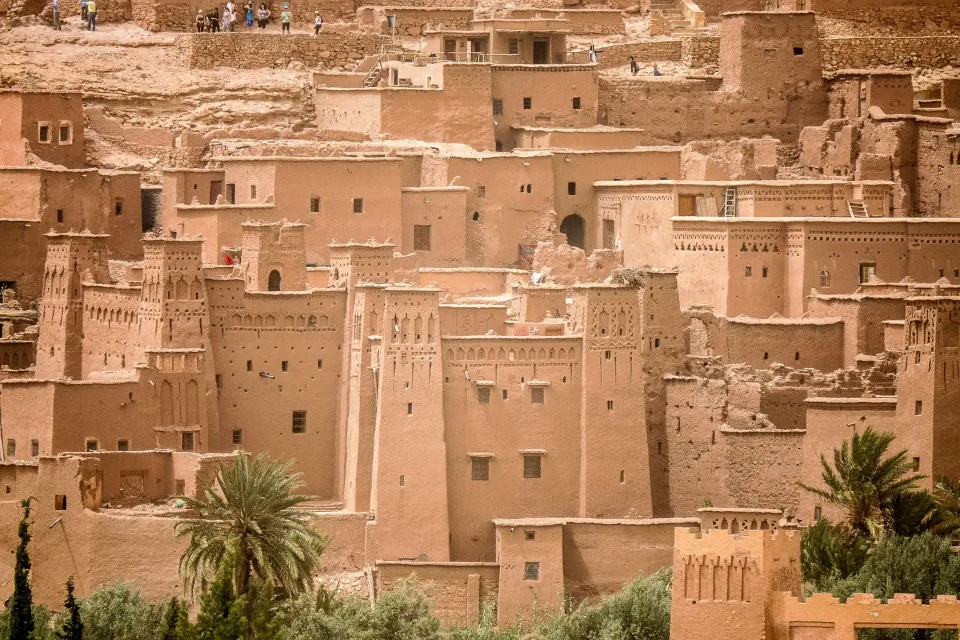 Earthen towers and houses of the Aït Benhaddou ksar rising above palm trees