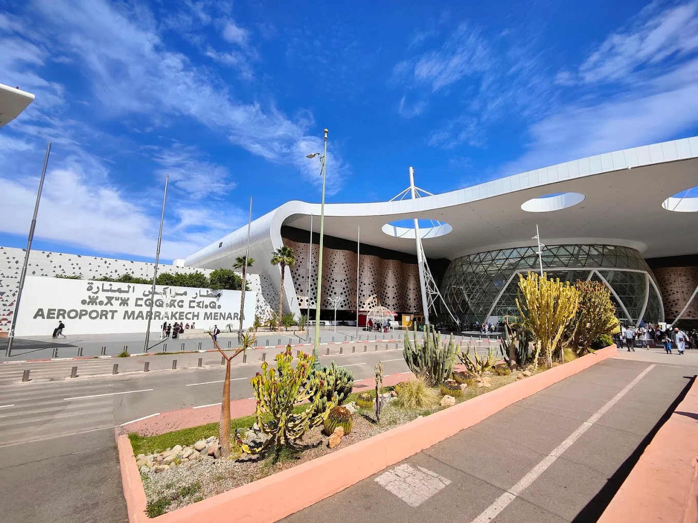 Modern white terminal of Marrakech Menara Airport with a cactus garden in front